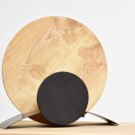 lampe ronde en bois claire et metal pose sur un meuble