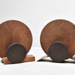 deux lampes ronde en bois de noyer et metal pose sur un meuble