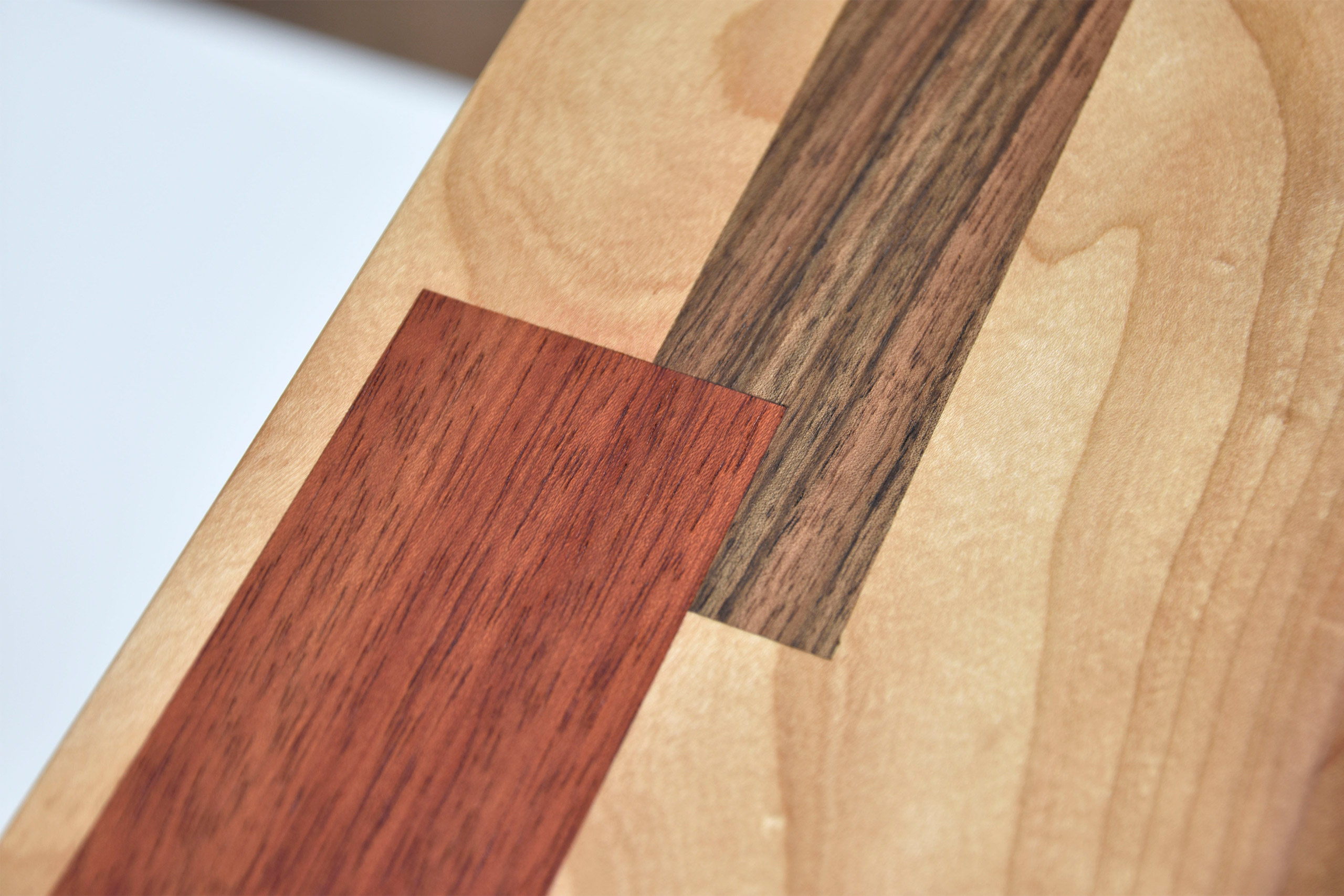detal d'un plateau de bois de cerisier avec des inserts de marquetterie en bois exotiques