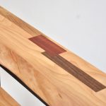 detal d'un plateau de bois de cerisier avec des inserts de marquetterie en bois exotiques