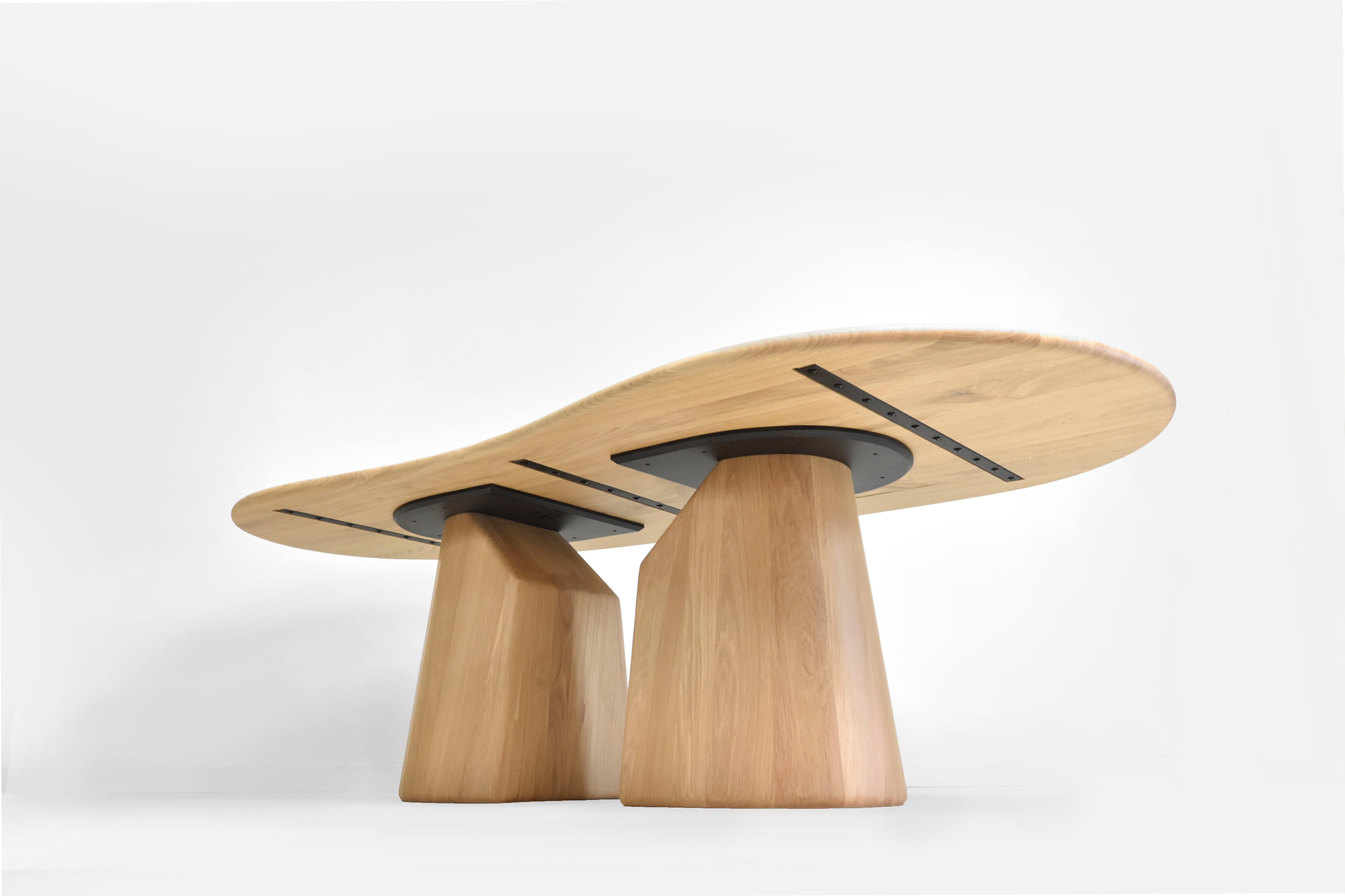 vue d'ensemble d'une table de salle à manger exclusive avec ses pieds d'éléphants et son plateau asymétrique