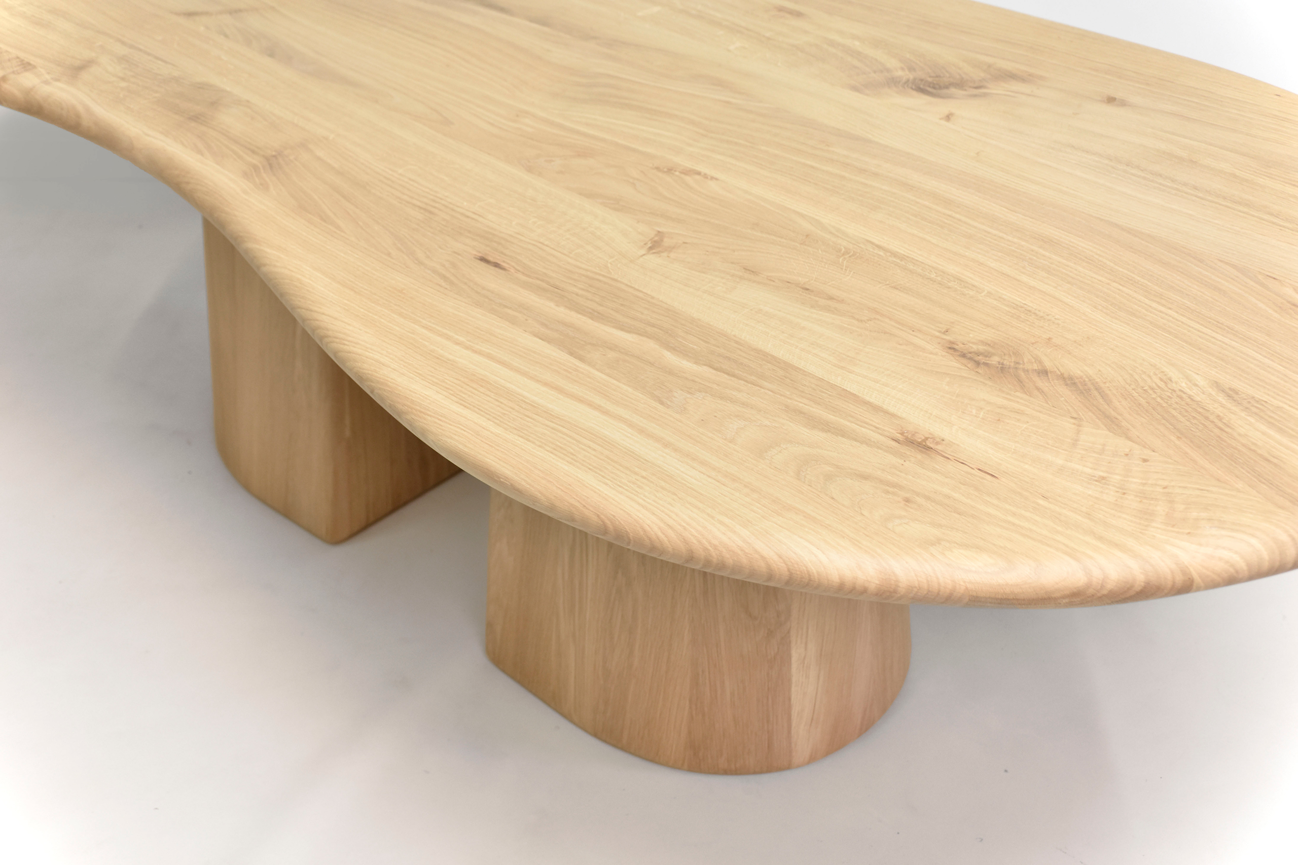 plateau de table haut de gamme avec une finition satinée et un bord arrondi en bois clair